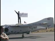 Astronaut Michael Melville holds a sign